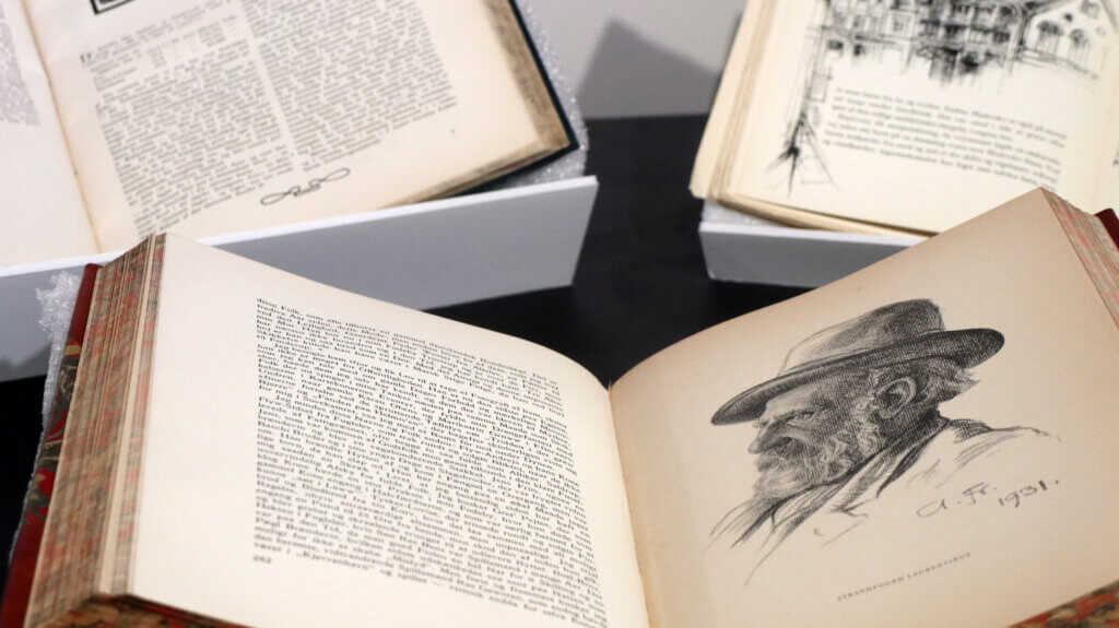 A close-up photo of a display of three books. One has an illustration of a man wearing a hat.