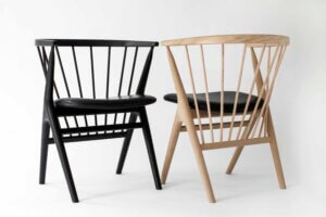 Two chairs one is all black, the other is light wood and a dark seat.