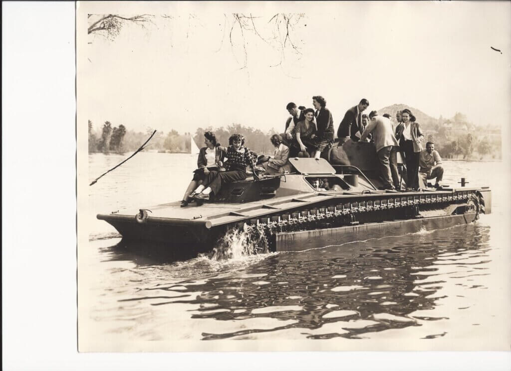 Corinne Kellar posing on a tank with other riveters.