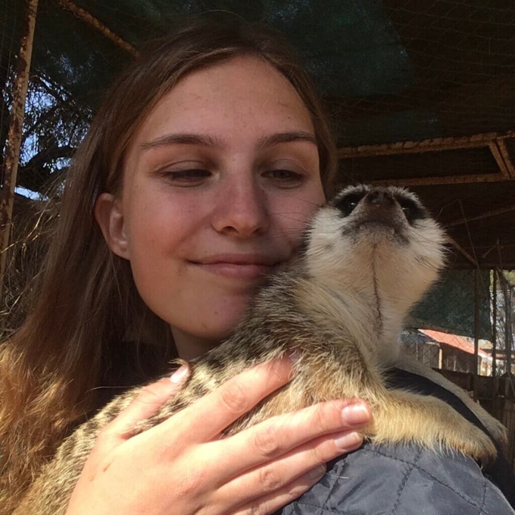 A meerkat rests upon Nathalie Nielsen's shoulder.