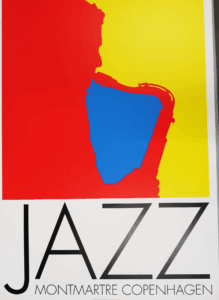 A red silhouette of a man playing saxophone emerges from the left of the poster, framed with a blue block in the center and a yellow block on the right. Below the man, text reads "Jazz. Montmartre Copenhagen."