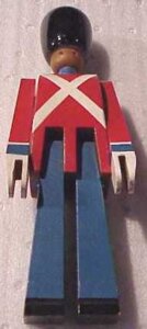Wooden toy soldier with black hat, wearing red coat with white trim and blue pants.