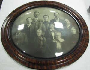 Framed black and white photograph of a family in a circular wooden frame.
