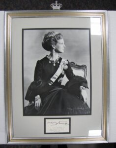 Framed picture of a woman in profile. she is wearing a dress and a small crown.