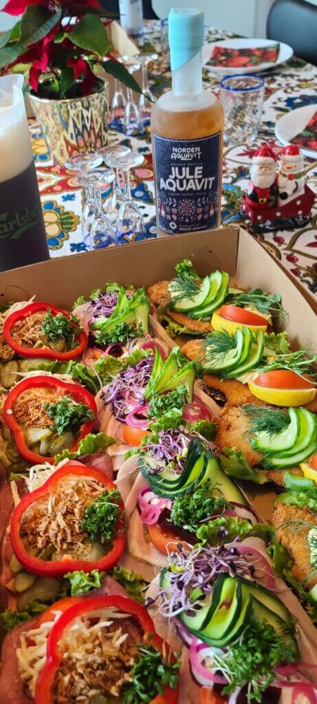 The 2024 release of Jule Aquavit. The bottle is frosted and placed behind authentic smørrebrød.