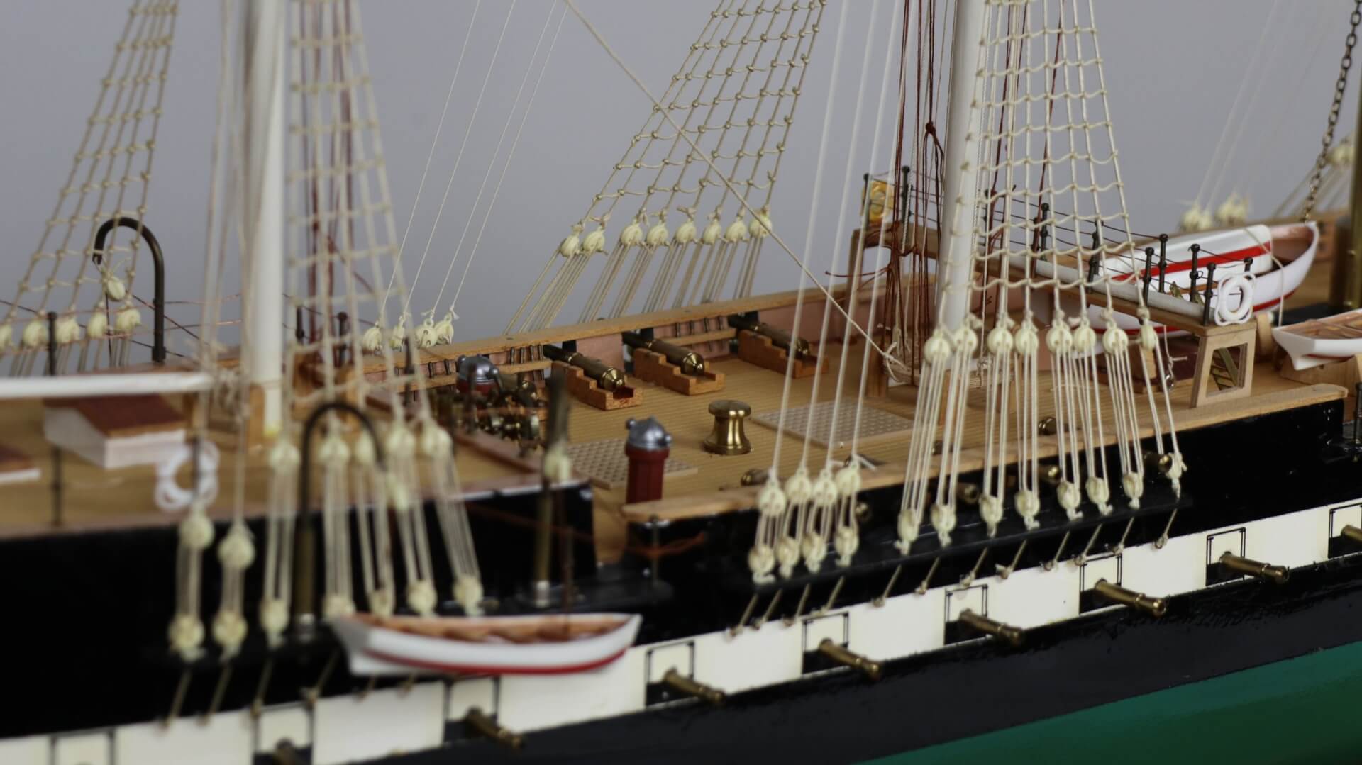 Close up of rigging and cannons of a model ship.