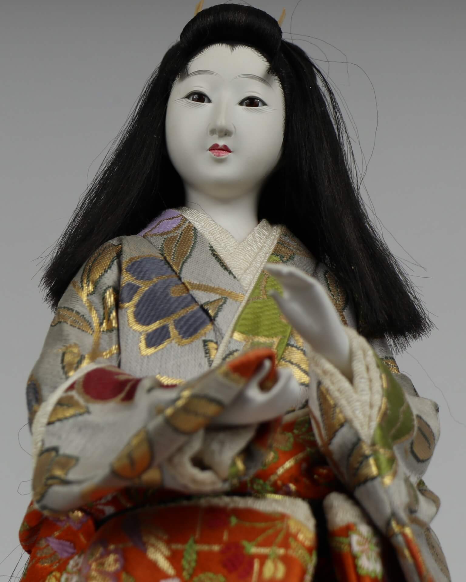Face of Japanese doll. The face is white with red lipstick.
