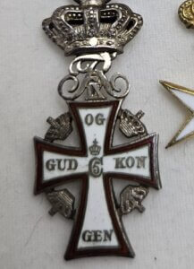 Medal featuring a cross with a crown and royal insignia above it. Text on the cross reads "Gud og Kongen."