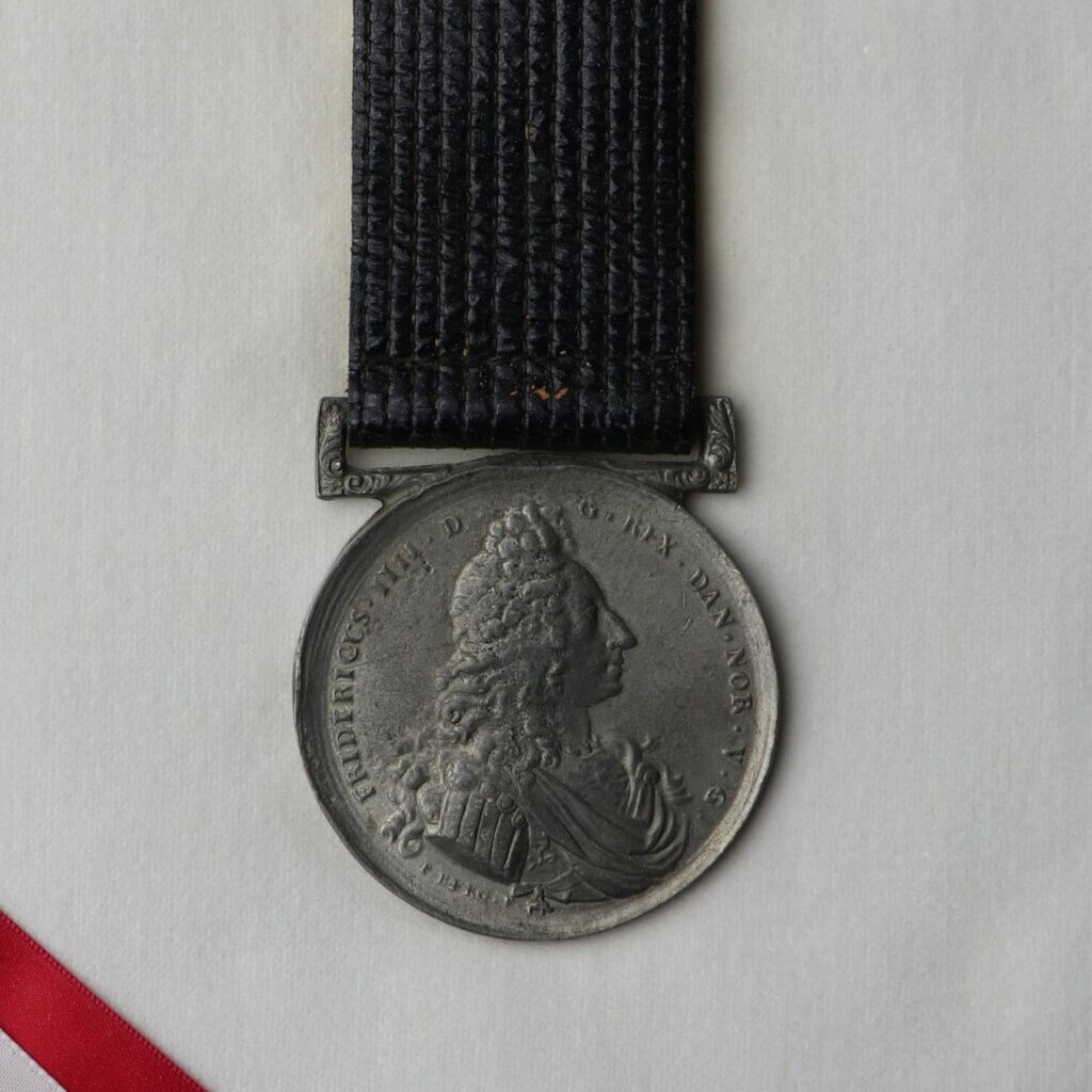 Silver medal with black leather strap