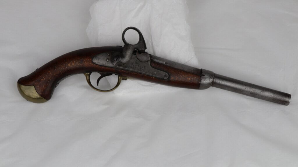 Flintlock pistol with a dark wooden handle and brass accents.