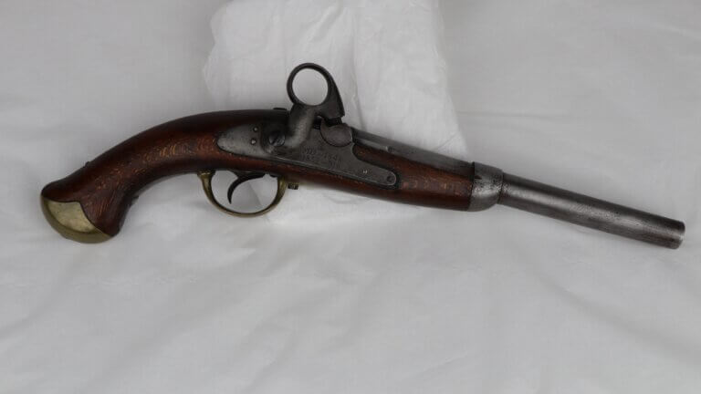 Flintlock pistol with a dark wooden handle and brass accents.