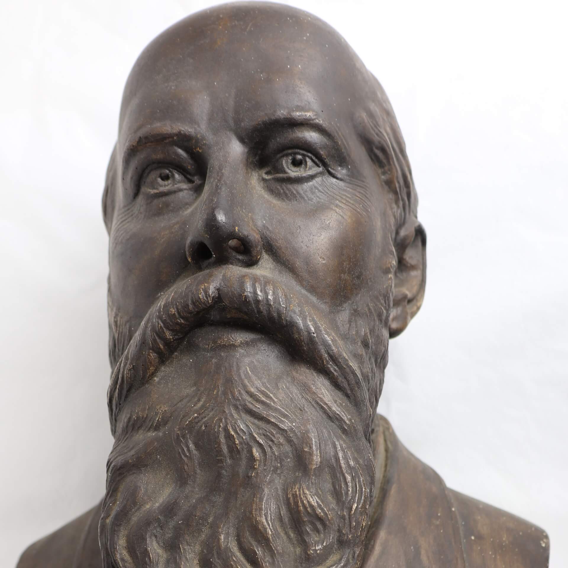 Bronze bust of a balding, bearded man, with detailed wrinkles.