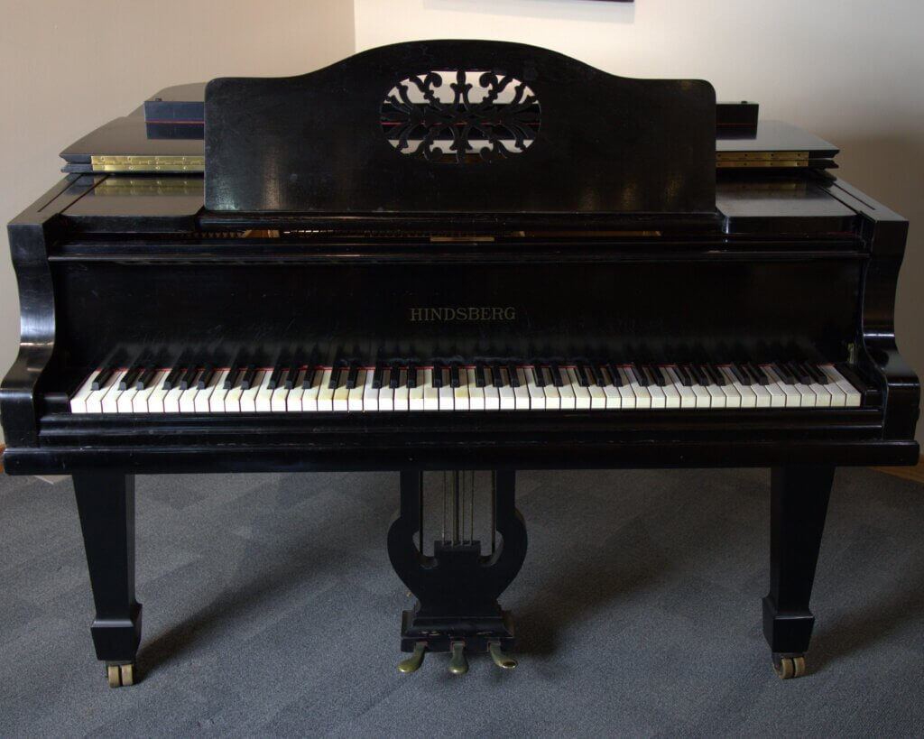 Black piano with ivory keys.