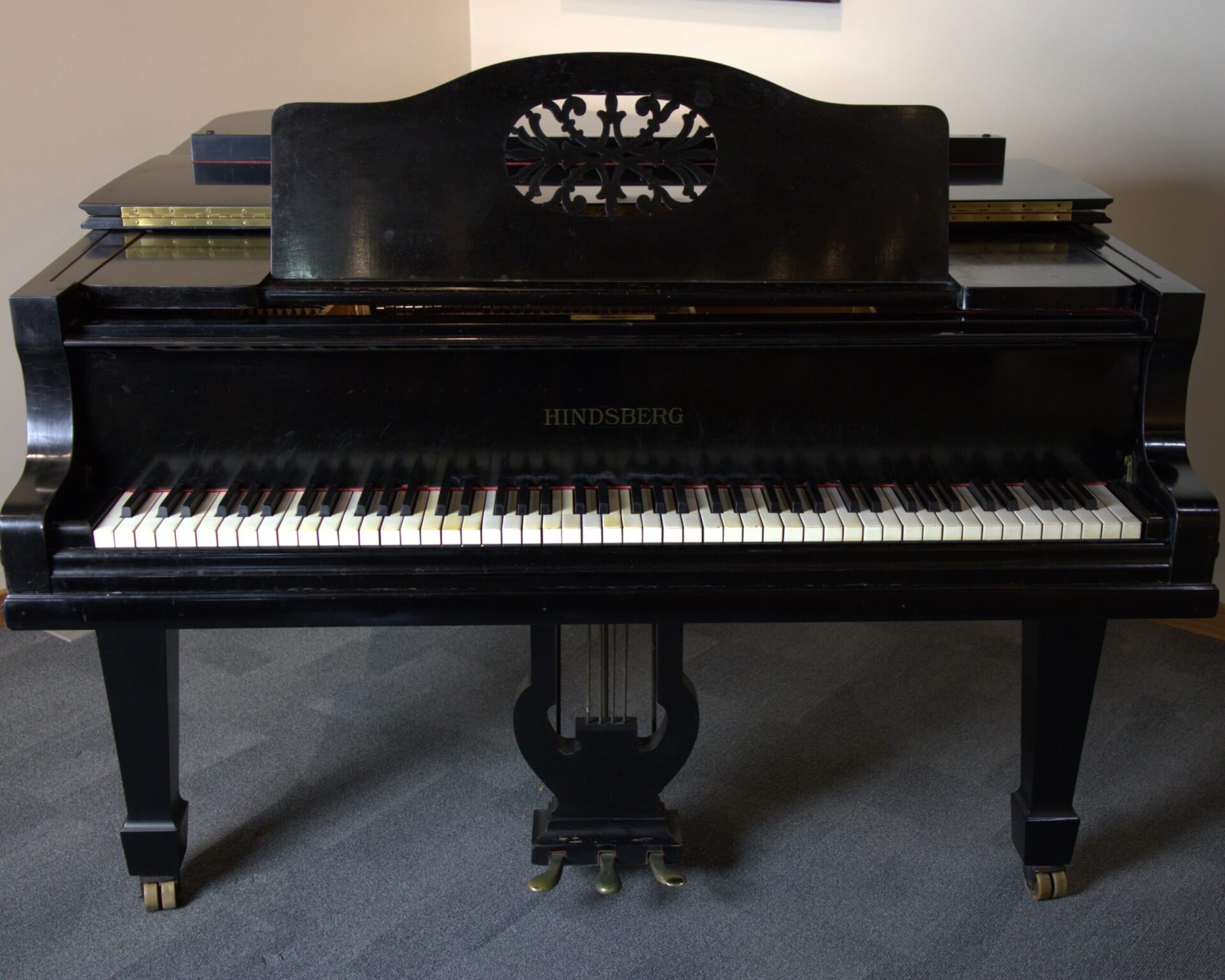 Black piano with ivory keys.