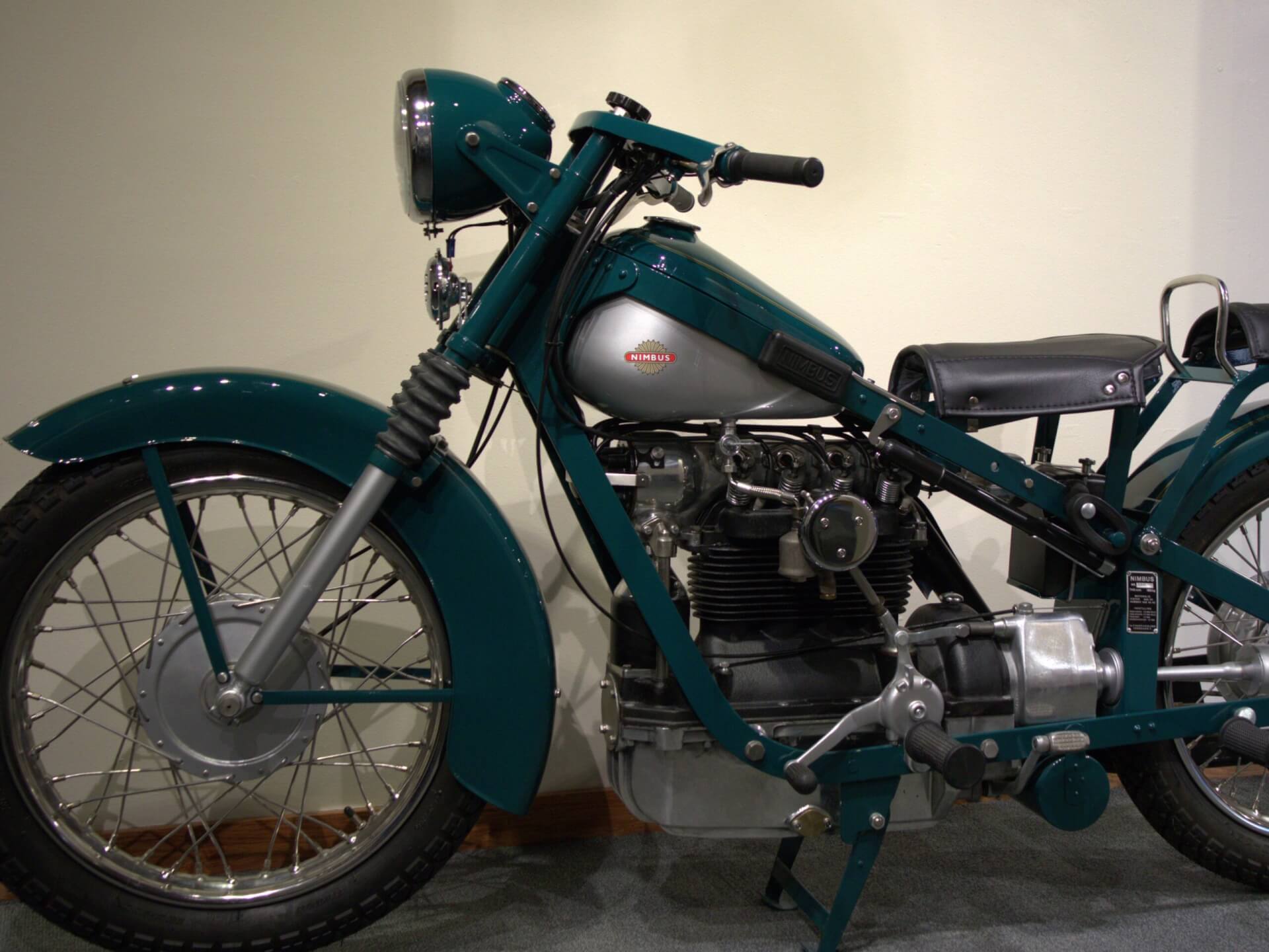 Green and silver motorcycle with two leather seats.