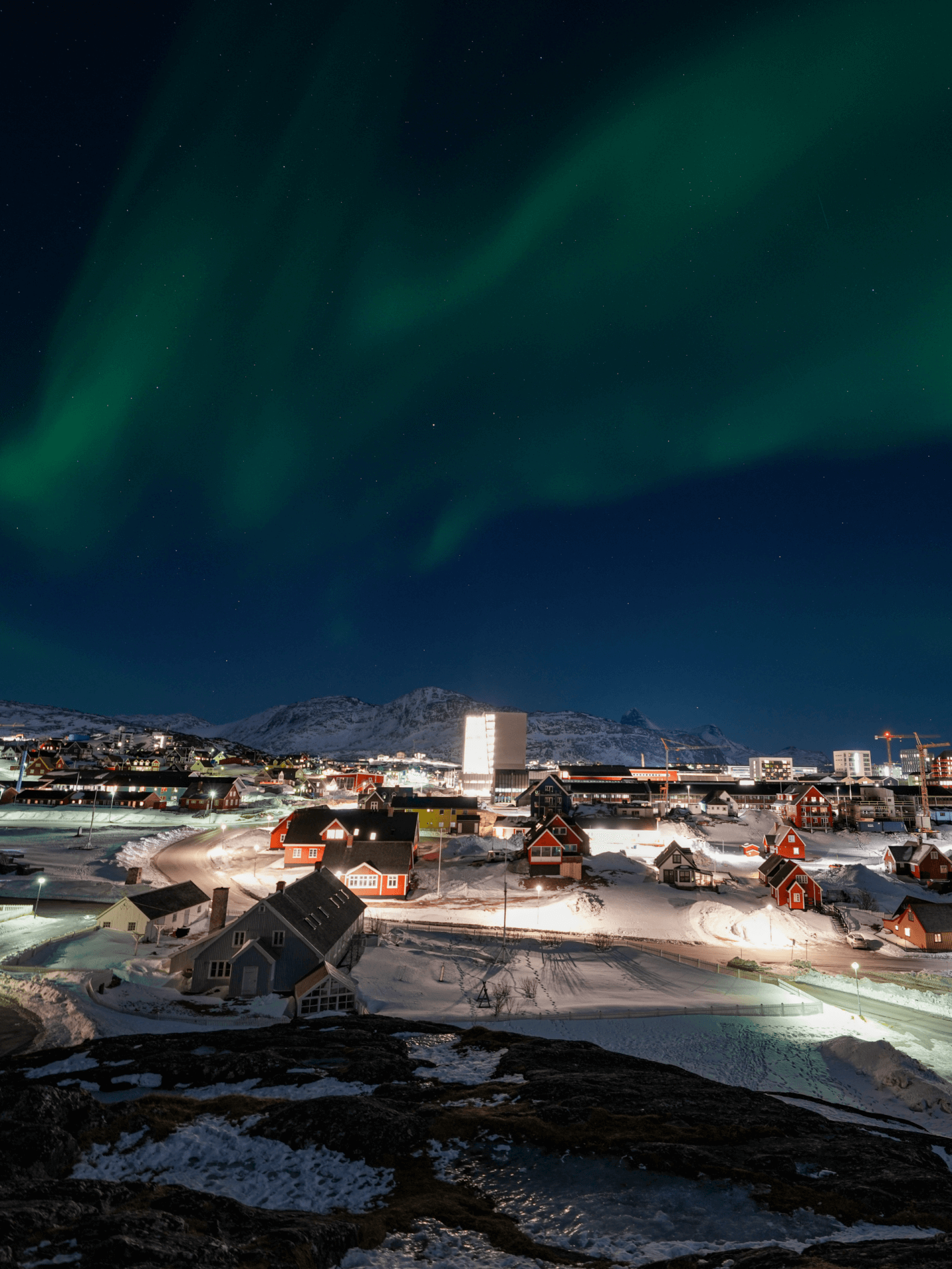 The skyline of Nuuk, Greenland, under the northern lights. 