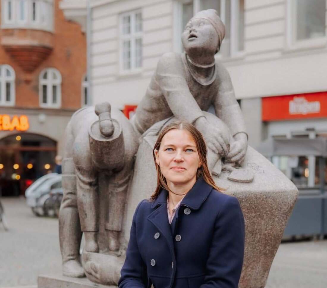 Martine Lind Krebs sitting before the Greenland Monument in Copenhagen, Denmark.